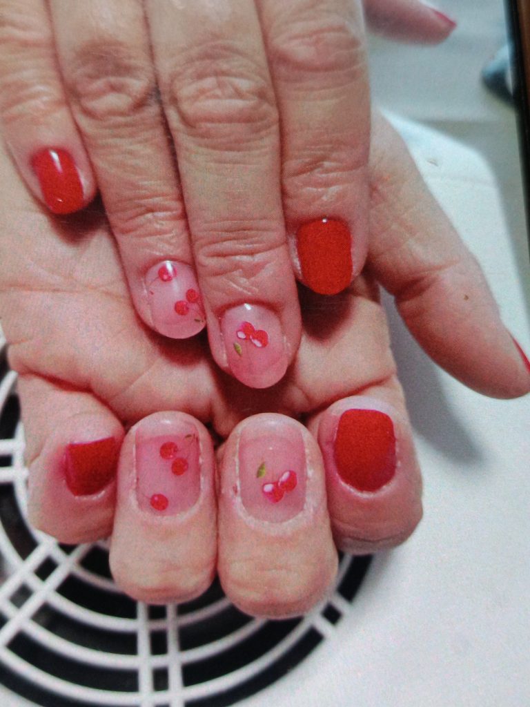 ongles naturels avec un rouge flamboyant et des stickers cerise